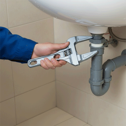 Clé à molette chromée réparant des tuyaux de salle de bain