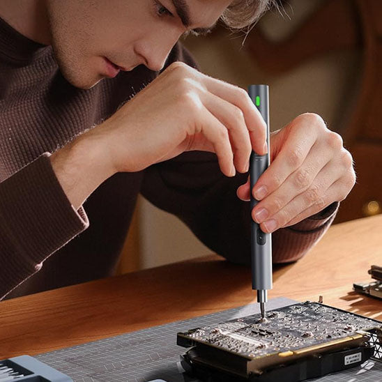 Homme dévisse composant électronique avec tournevis electrique