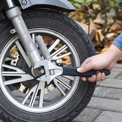 Clé à molette serrant un boulon de pneu de moto