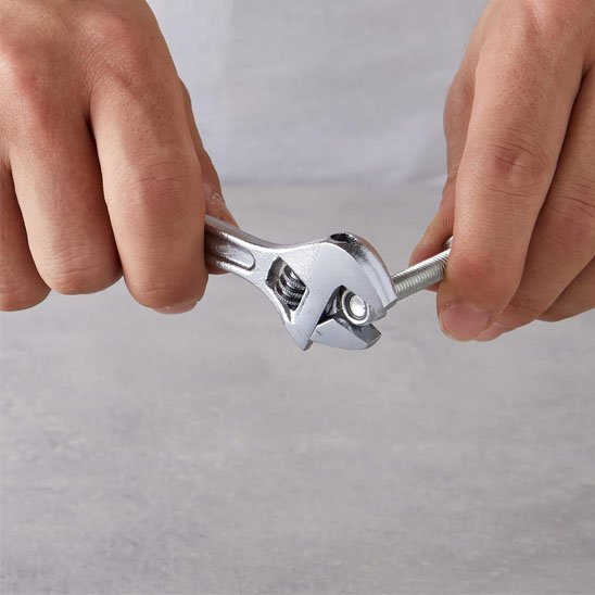 Clé à molette serrent un écrou sur une vis