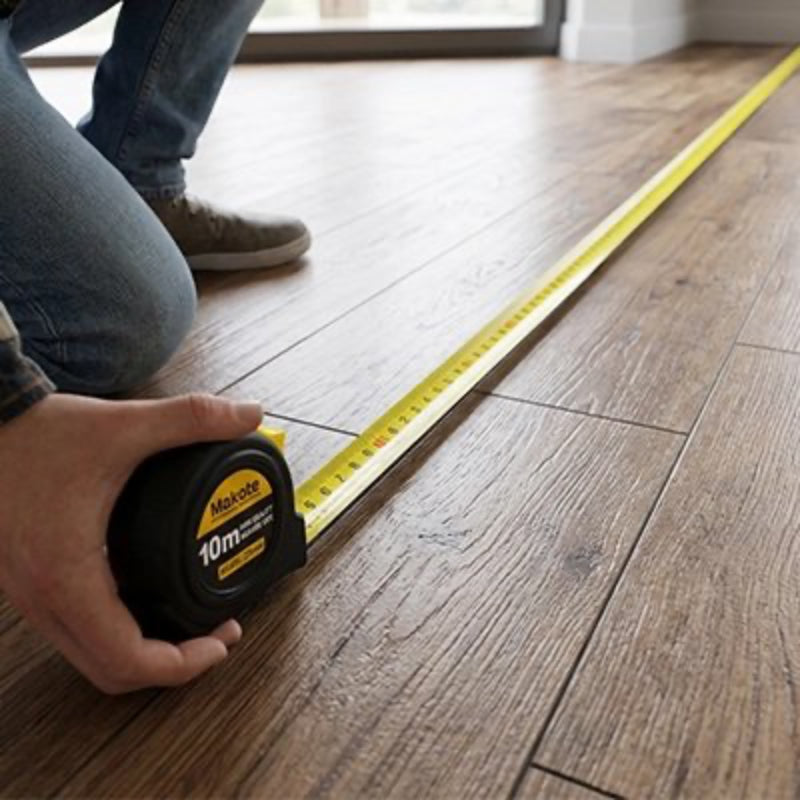 Metre ruban de 10m jaune et noir mesurant un plancher 