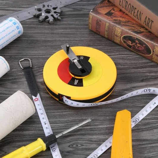 Mètre ruban jaune de 20 mètre sur une  surface  grise avec d'autres objets