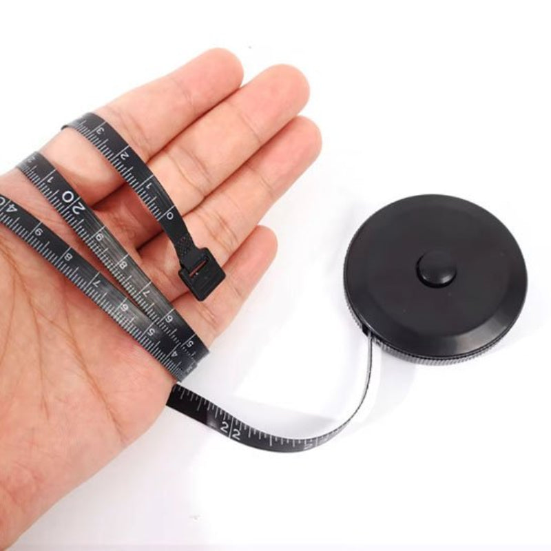 Metre ruban noir entourant une main
