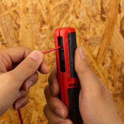 Pince à dénuder et un câble électrique rouge