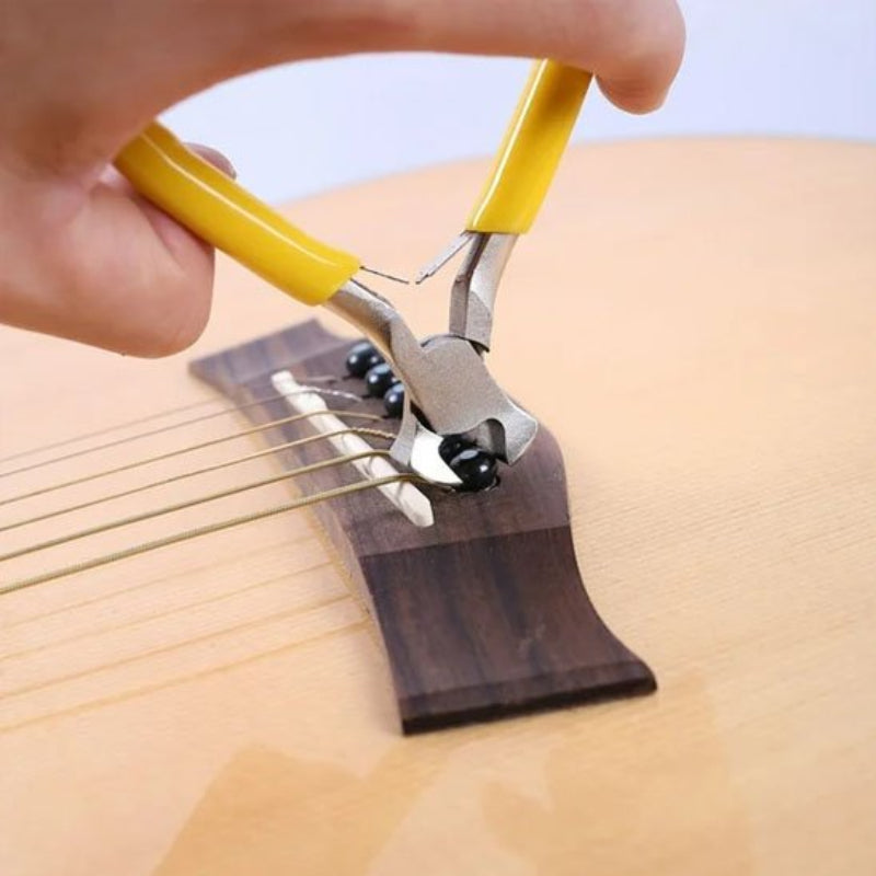 Pince coupante jaune avec des fils de guitard