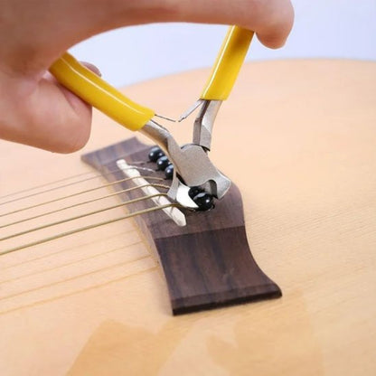 Pince coupante jaune avec des fils de guitard