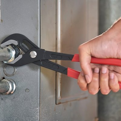 Pince multiprise rouge et noir dans une main