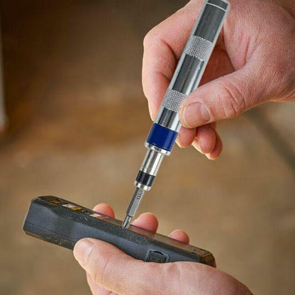 Tournevis avec embout dans la main d'une personne qui répare un appareil