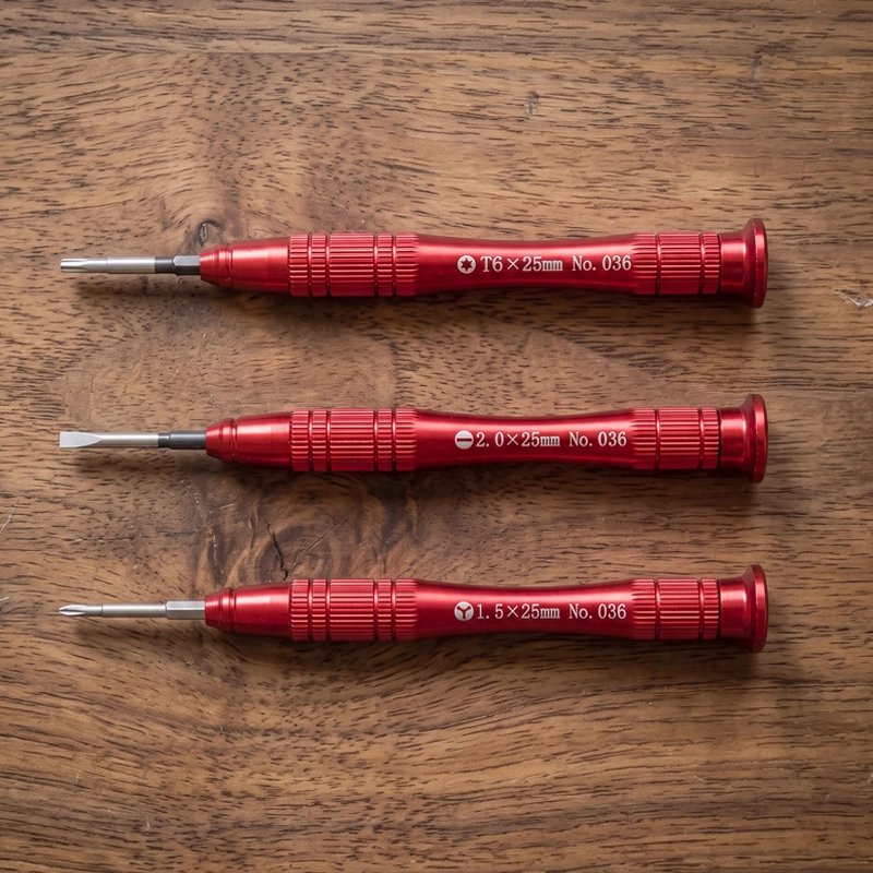 Tournevis rouge rangé en trio sur une table
