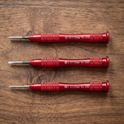 Tournevis rouge rangé en trio sur une table